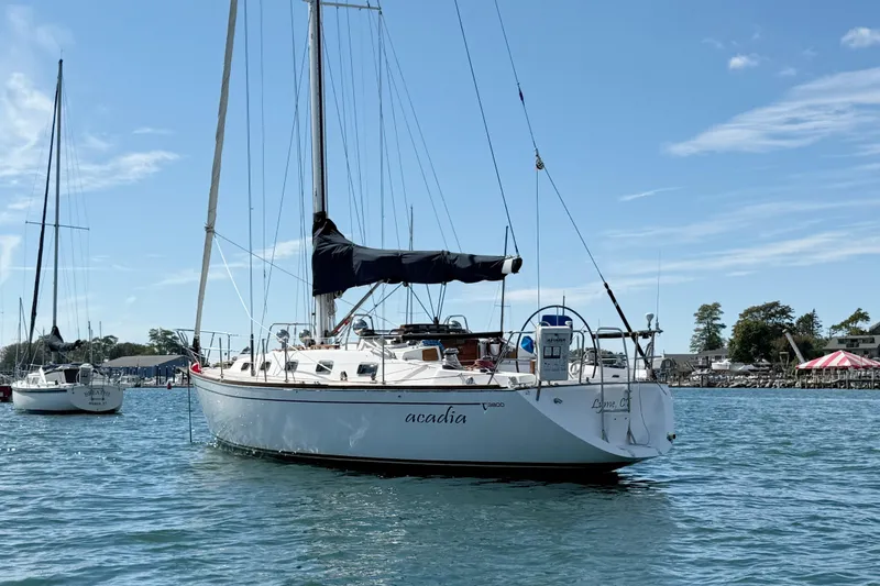 Slide: The Image of Sailboat Tartan 3800, 1997 model, anchored in a scenic harbor under a clear blue sky. - 11