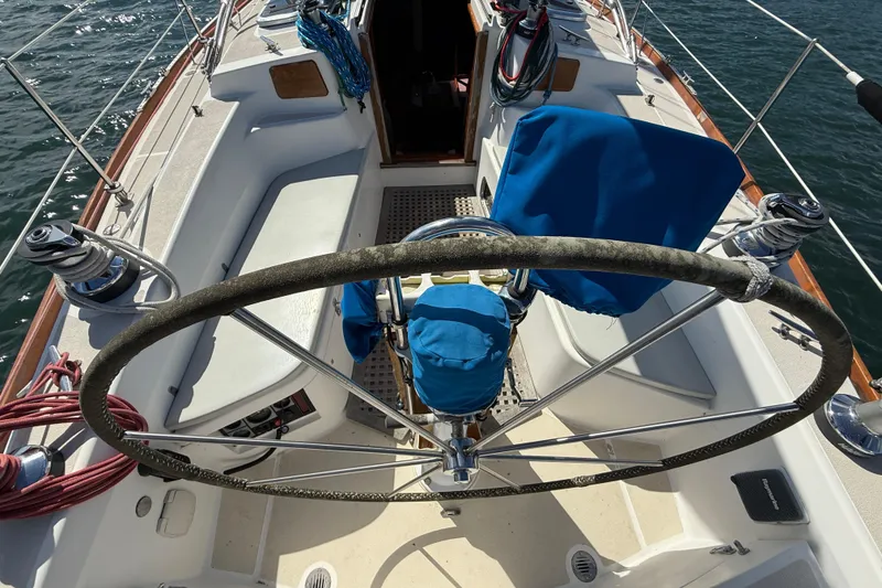 Slide: The Image of Cockpit of 1997 Tartan 3800 sailboat with steering wheel and blue covers. - 14