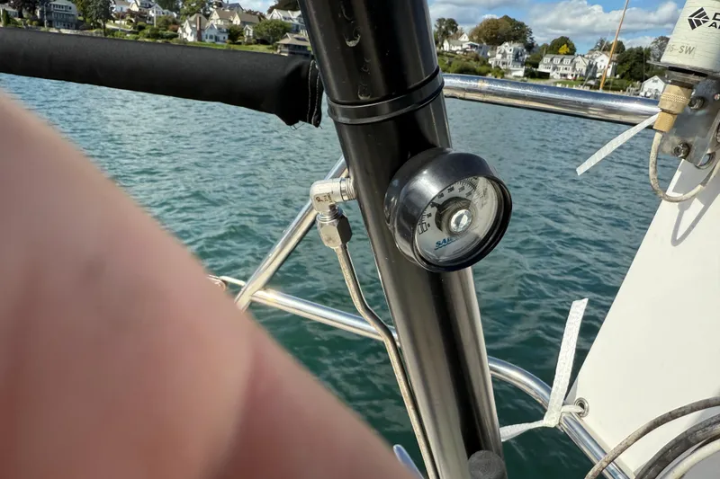 Slide: The Image of Sailboat Tartan 3800, 1997 model, with a gauge on deck, near coastal homes. - 27