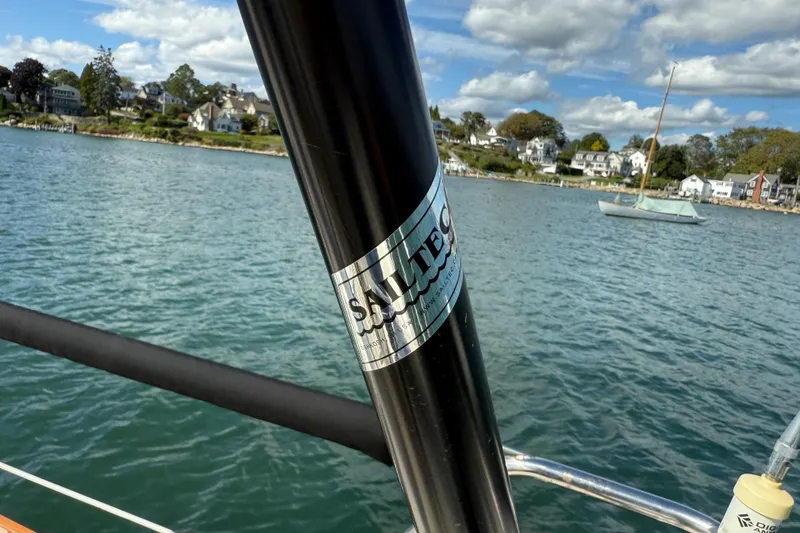 Slide: The Image of Sailboat mast on Tartan 3800, 1997 model, with coastal houses in the background. - 28