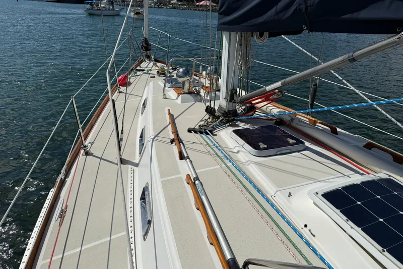 Slide: The Image of 1997 Tartan 3800 sailboat deck with rigging, solar panels, and scenic water view. - 31