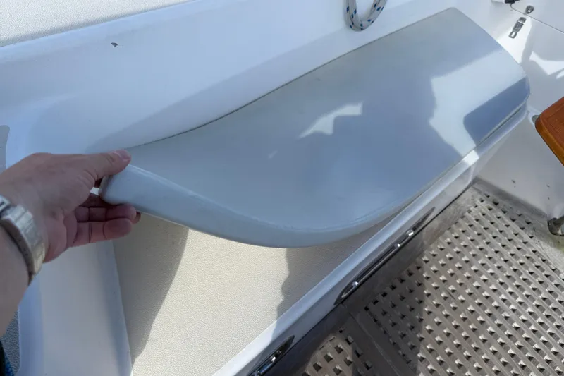 Slide: The Image of Hand lifting seat on 1997 Tartan 3800 boat, showcasing interior design details. - 42