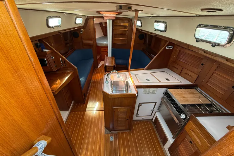 Slide: The Image of Interior of 1997 Tartan 3800 sailboat with wooden cabinetry and compact kitchen area. - 44