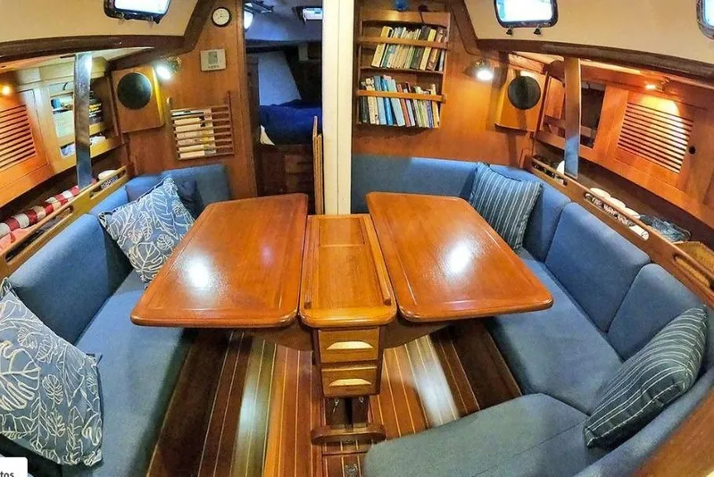 Slide: The Image of Interior of a 1997 Tartan 3800 sailboat with wooden table and blue seating. - 46