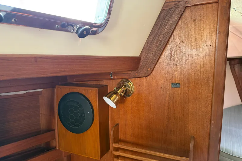 Slide: The Image of Interior of a 1997 Tartan 3800 sailboat featuring wooden paneling and a brass light fixture. - 53
