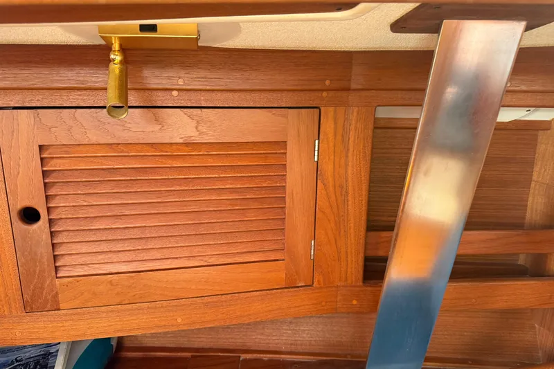 Slide: The Image of Wooden interior of a 1997 Tartan 3800 sailboat with brass and metal accents. - 55