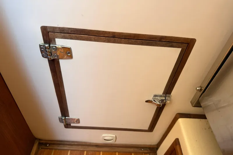 Slide: The Image of Hinged wooden hatch door inside a 1997 Tartan 3800 boat interior. - 62