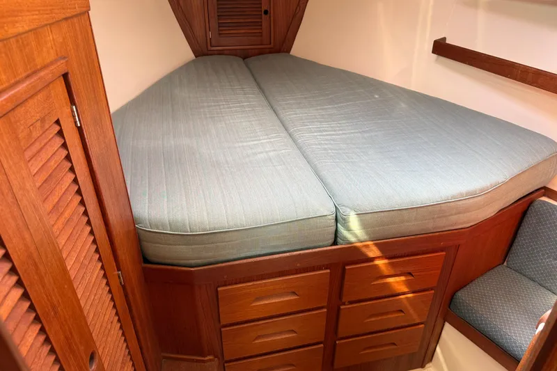 Slide: The Image of Cozy cabin interior of 1997 Tartan 3800 sailboat with wooden storage and cushioned bed. - 69