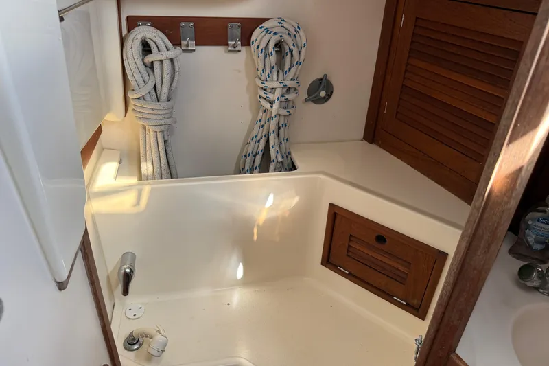 Slide: The Image of Interior of 1997 Tartan 3800 sailboat with ropes and wooden storage. - 85