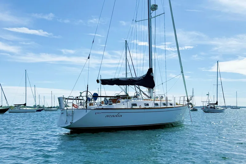Slide: The Image of Sailboat Tartan 3800, 1997 model, anchored in a sunny harbor with clear skies. - 9