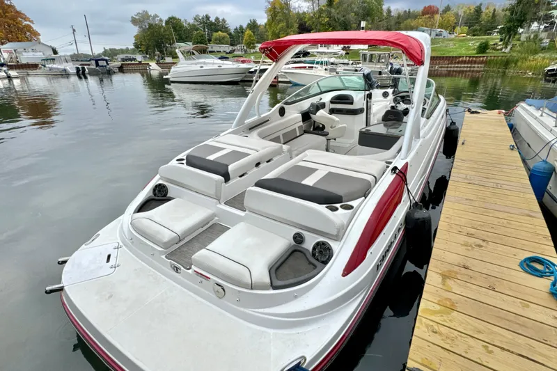 Slide: The Image of 2018 Rinker 29QX BR boat docked, featuring spacious seating and sleek design. - 0