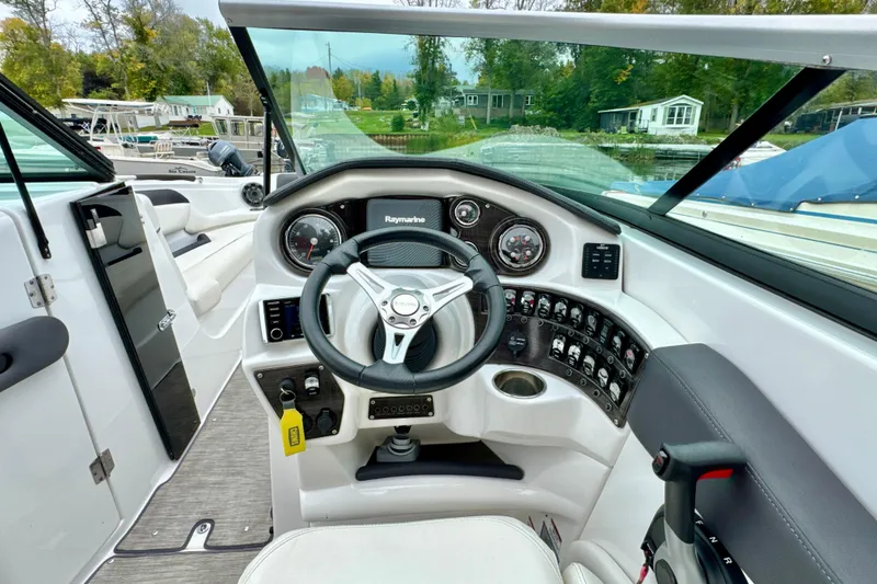 Slide: The Image of 2018 Rinker 29QX BR boat cockpit with steering wheel and control panel. - 10