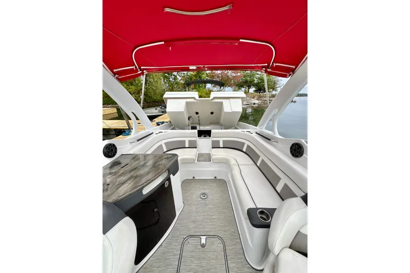 Slide: The Image of 2018 Rinker 29QX BR boat interior with red canopy, sleek seating, and modern design. - 22