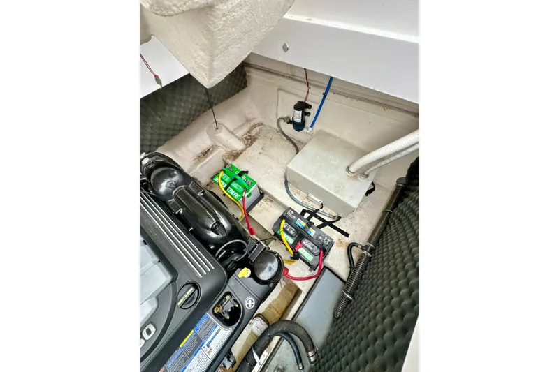 Slide: The Image of Engine compartment of a 2018 Rinker 29QX BR boat, showing battery and wiring. - 25