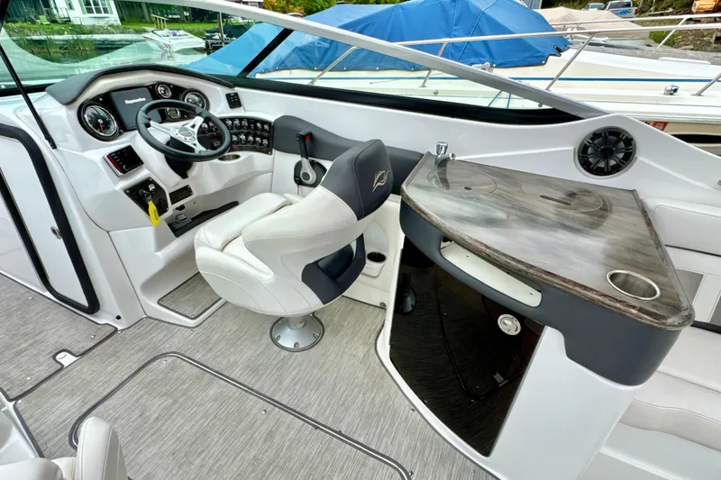 Slide: The Image of 2018 Rinker 29QX BR boat interior with helm, steering wheel, and seating. - 8