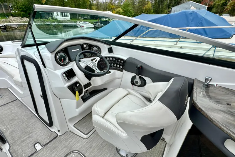 Slide: The Image of 2018 Rinker 29QX BR boat interior with steering wheel and control panel. - 9