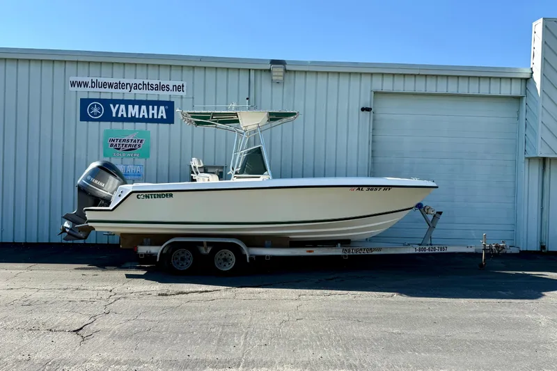 The Image of 1997 Contender 23 Open boat on trailer, parked outside Yamaha dealership. - 0