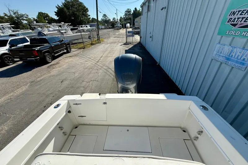 Slide: The Image of 1997 Contender 23 Open boat with outboard motor in a marina setting. - 6