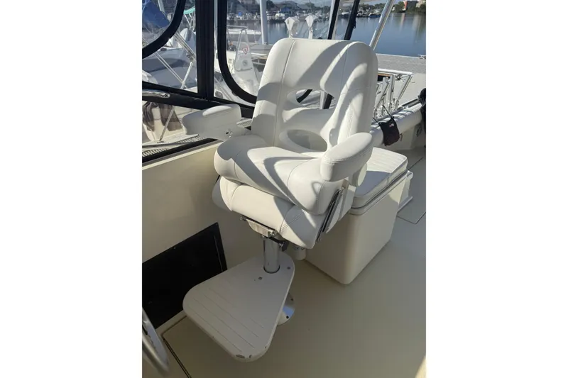 Slide: The Image of Captain's chair on a 2002 Carolina Classic 28 boat, with marina view. - 12