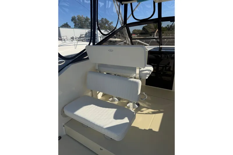 Slide: The Image of 2002 Carolina Classic 28 boat interior with white seating and clear windows. - 14