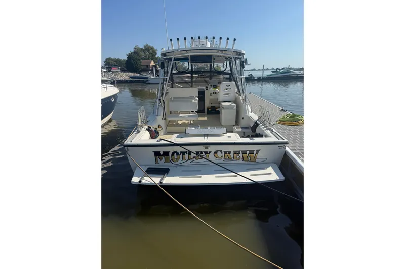 Slide: The Image of 2002 Carolina Classic 28 boat docked, rear view with fishing equipment. - 2