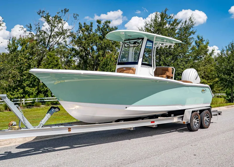 The Image of 2026 Sea Hunt Ultra 239 boat on trailer, parked on a sunny day. - 1