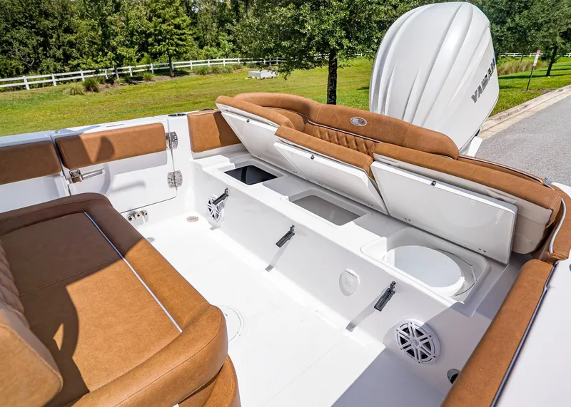 Slide: The Image of 2026 Sea Hunt Ultra 239 boat interior with brown seating and storage compartments. - 10