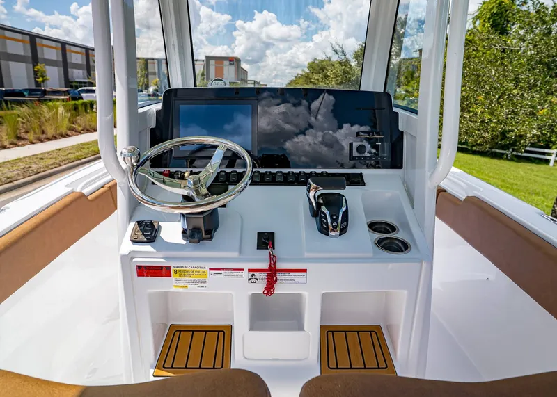 Slide: The Image of 2026 Sea Hunt Ultra 239 boat console with steering wheel and controls, outdoors. - 14