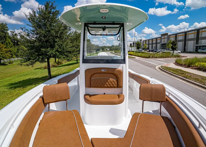Slide: The Image of 2026 Sea Hunt Ultra 239 boat interior with brown seating, parked outdoors. - 21
