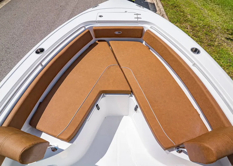 Slide: The Image of 2026 Sea Hunt Ultra 239 boat with brown cushioned seating in the bow area. - 23