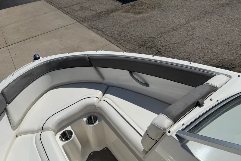 Slide: The Image of 2014 Bayliner 185 Bowrider boat interior with cushioned seating and cup holders. - 10