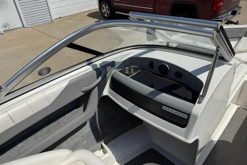Slide: The Image of 2014 Bayliner 185 Bowrider interior with dashboard and windshield, parked outdoors. - 16