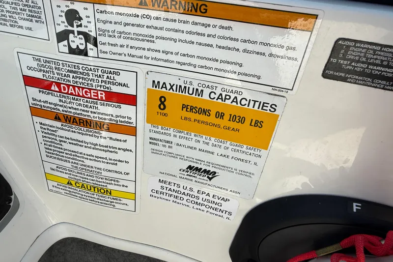 Slide: The Image of 2014 Bayliner 185 Bowrider safety labels showing maximum capacity and warnings. - 23