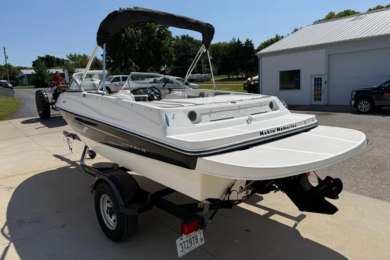 Slide: The Image of 2014 Bayliner 185 Bowrider boat on trailer, parked outdoors near a building. - 4