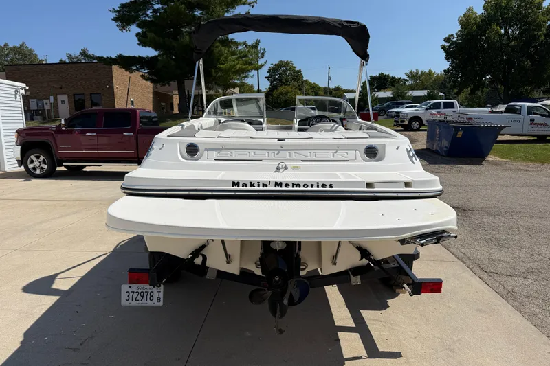 Slide: The Image of 2014 Bayliner 185 Bowrider boat on trailer, parked outdoors in sunny setting. - 5
