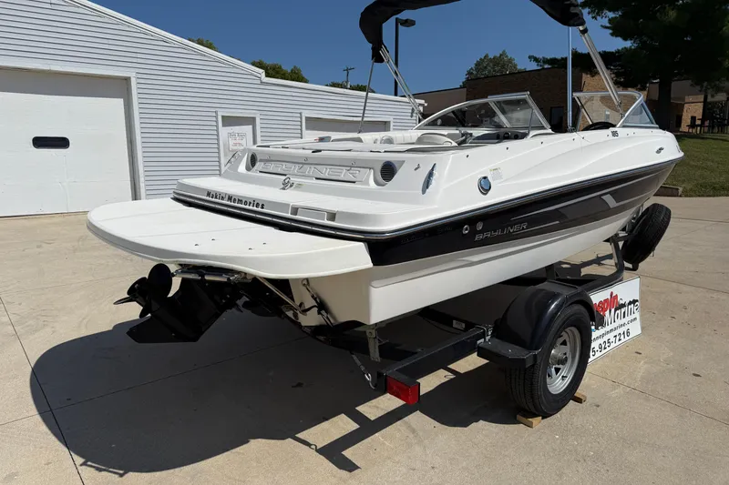 Slide: The Image of 2014 Bayliner 185 Bowrider boat on trailer, parked outdoors near a garage. - 6