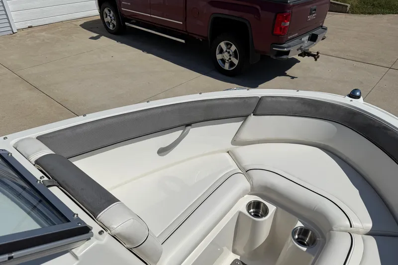 Slide: The Image of 2014 Bayliner 185 Bowrider boat interior with cushioned seating and cup holders. - 9