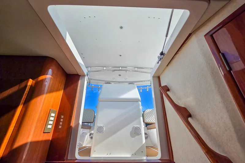 Slide: The Image of Interior view of 2005 Buddy Davis 35' Express yacht, showcasing elegant wood finishes and open hatch. - 14