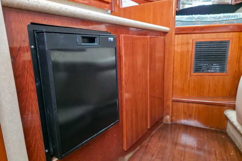 Slide: The Image of 2005 Buddy Davis 35' Express interior with wood paneling and compact refrigerator. - 15