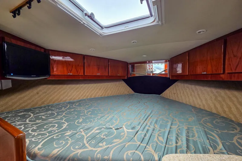 Slide: The Image of Interior cabin of 2005 Buddy Davis 35' Express with wood cabinets and patterned bedding. - 17