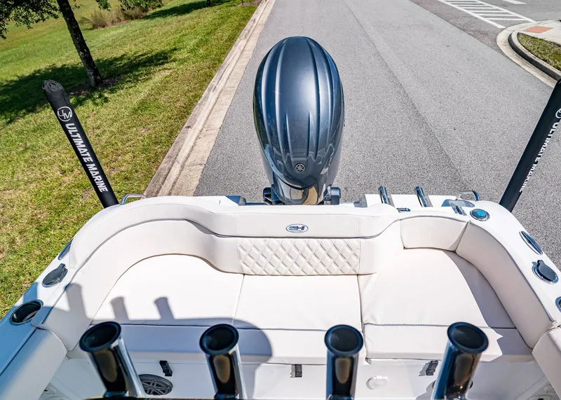 Slide: The Image of 2026 Sea Hunt Ultra 219 boat with cushioned seating and outboard motor on a road. - 11