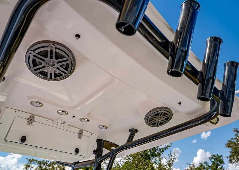 Slide: The Image of 2026 Sea Hunt Ultra 219 boat ceiling with speakers and rod holders against blue sky. - 16