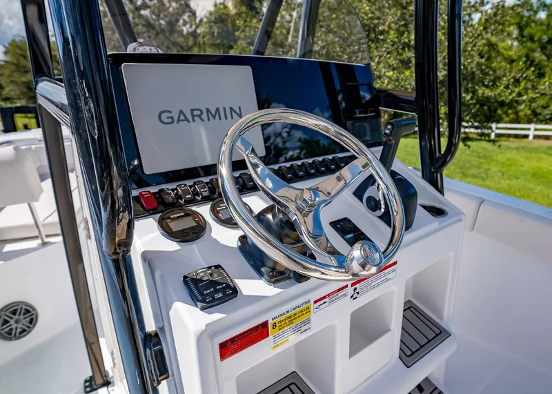 Slide: The Image of 2026 Sea Hunt Ultra 219 boat dashboard with Garmin navigation system and steering wheel. - 18