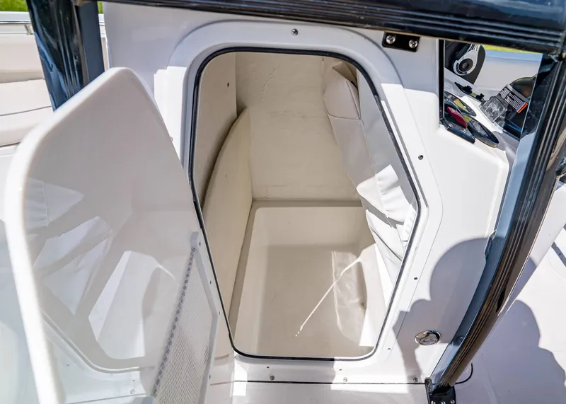 Slide: The Image of 2026 Sea Hunt Ultra 219 boat storage compartment with open door, showcasing interior space. - 19