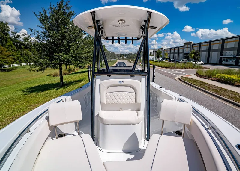 Slide: The Image of 2026 Sea Hunt Ultra 219 boat interior with seating, under a clear blue sky. - 24