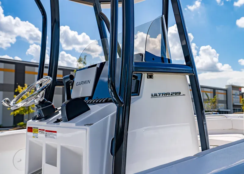 Slide: The Image of 2026 Sea Hunt Ultra 219 boat console with Garmin navigation, under a clear blue sky. - 5