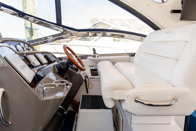 Slide: The Image of 2008 Regal Commodore 4060 yacht cockpit with white leather seating and wooden steering wheel. - 10
