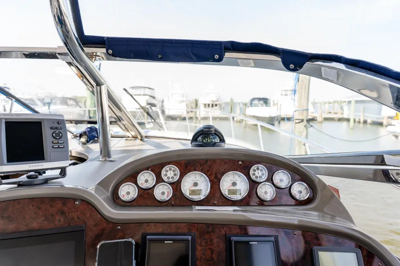 Slide: The Image of Cockpit view of 2008 Regal Commodore 4060 yacht with navigation instruments and marina background. - 13