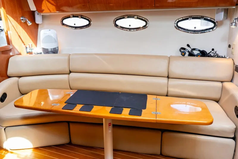 Slide: The Image of Luxurious interior of 2008 Regal Commodore 4060 yacht with beige leather seating and wooden table. - 16