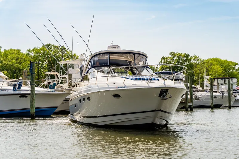 Slide: The Image of 2008 Regal Commodore 4060 yacht docked in a marina, surrounded by other boats. - 2